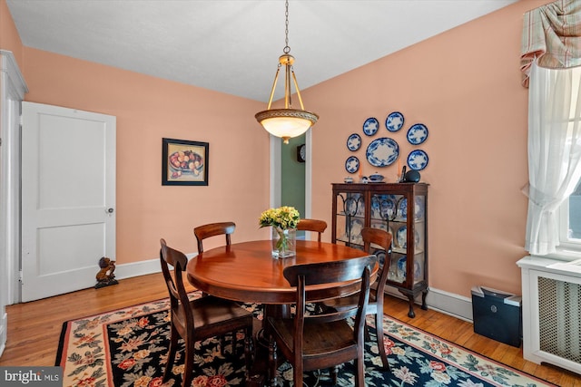 dining space with baseboards and wood finished floors