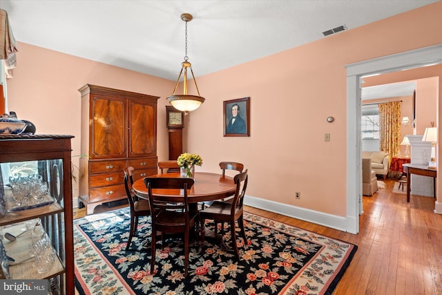 dining space featuring baseboards, visible vents, and light wood-type flooring