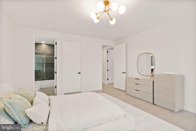 bedroom with connected bathroom, baseboards, an inviting chandelier, and light wood-style flooring