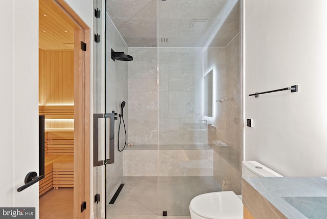 full bath featuring tiled shower, toilet, and vanity