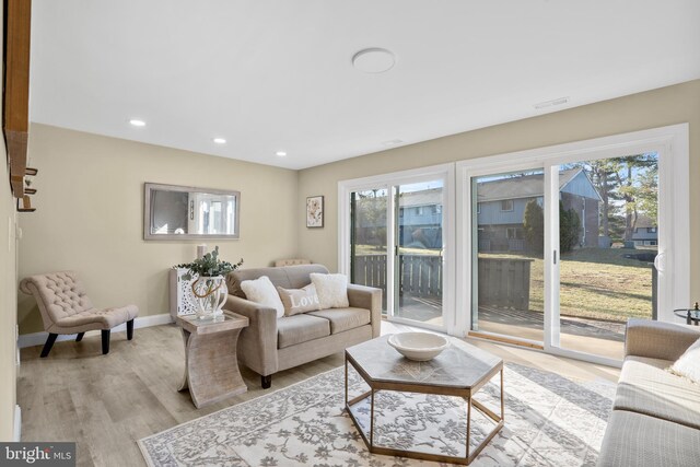 living room featuring recessed lighting, baseboards, a healthy amount of sunlight, and wood finished floors