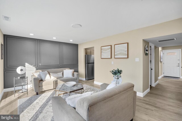 living room with visible vents, recessed lighting, baseboards, and light wood-style floors