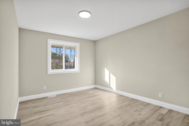 spare room featuring wood finished floors and baseboards