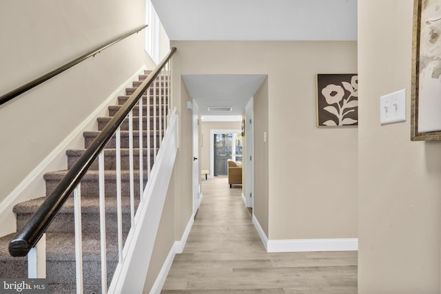 stairway featuring baseboards and wood finished floors