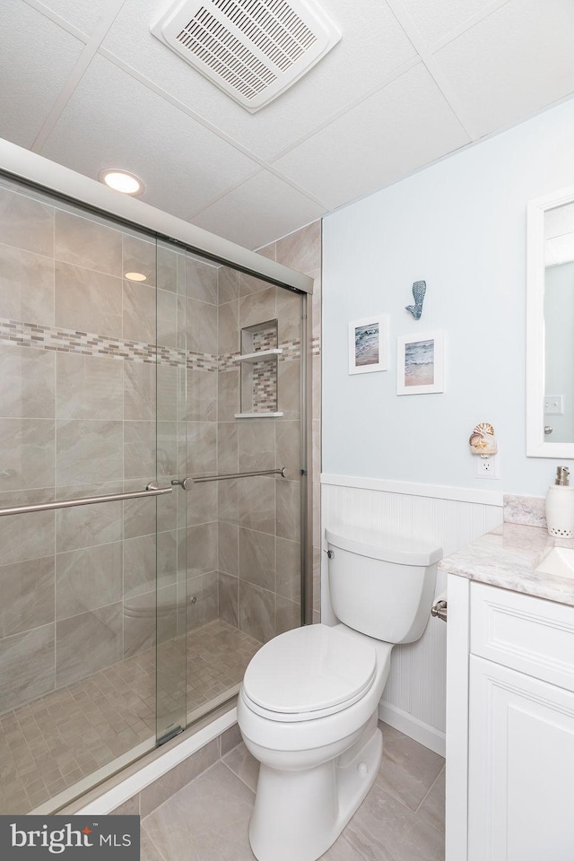 bathroom with vanity, visible vents, a shower stall, tile patterned floors, and toilet