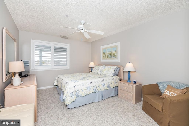 bedroom with baseboards, light carpet, a textured ceiling, and ceiling fan