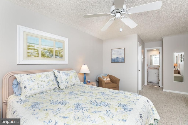 bedroom featuring a ceiling fan, baseboards, carpet floors, ensuite bathroom, and a textured ceiling