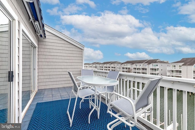 balcony featuring outdoor dining area and a residential view