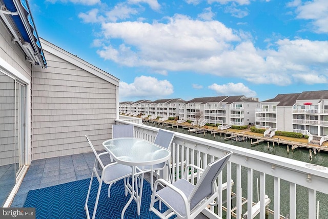 balcony with a residential view and a water view