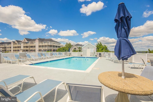 community pool with a patio and fence