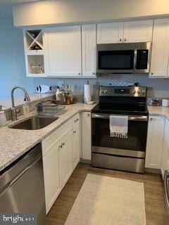 kitchen featuring a sink, white cabinets, dark wood finished floors, and stainless steel appliances