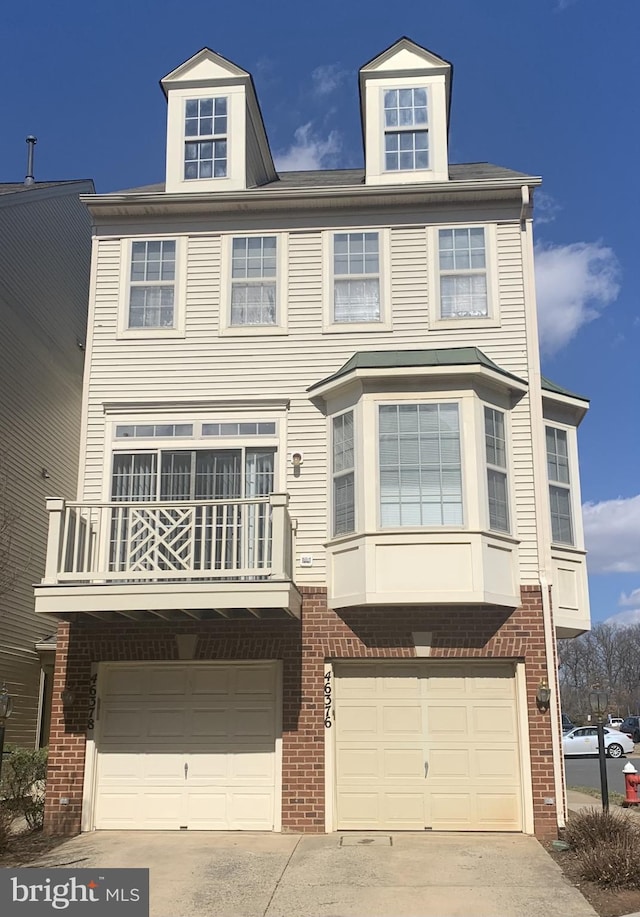 view of property with an attached garage, brick siding, and driveway