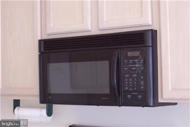 interior details with white cabinets and black microwave