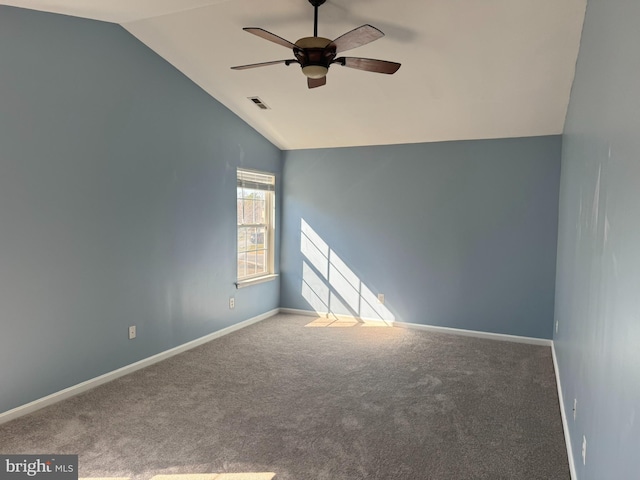 carpeted empty room with visible vents, baseboards, ceiling fan, and vaulted ceiling