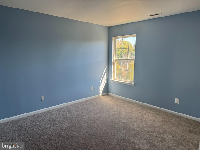 carpeted spare room with baseboards and visible vents