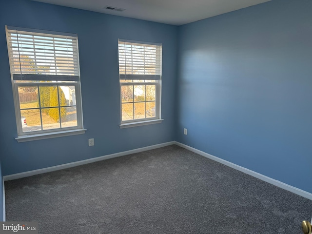 spare room featuring visible vents, carpet, and baseboards