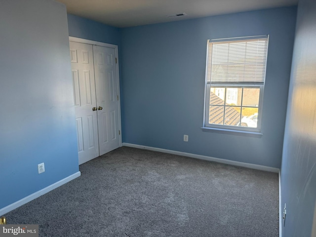 unfurnished bedroom featuring visible vents, baseboards, and carpet flooring