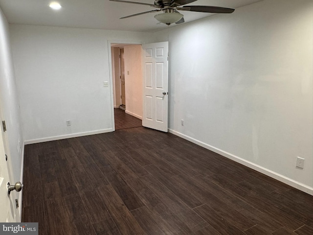 unfurnished room featuring baseboards, dark wood-type flooring, and a ceiling fan