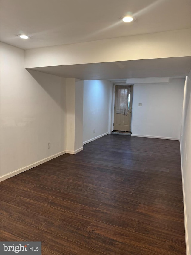 finished basement with dark wood finished floors, recessed lighting, and baseboards