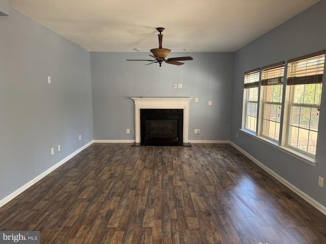 unfurnished living room featuring dark wood-type flooring, a fireplace with flush hearth, a ceiling fan, and baseboards