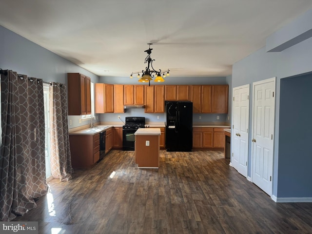 kitchen with black appliances, under cabinet range hood, a kitchen island, dark wood finished floors, and light countertops