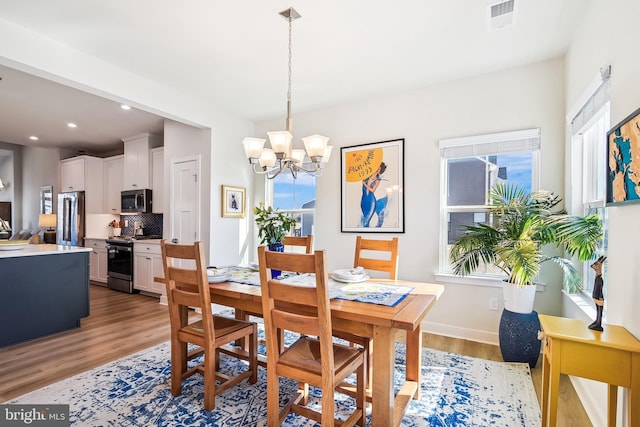 dining room with baseboards, visible vents, recessed lighting, a notable chandelier, and light wood-type flooring