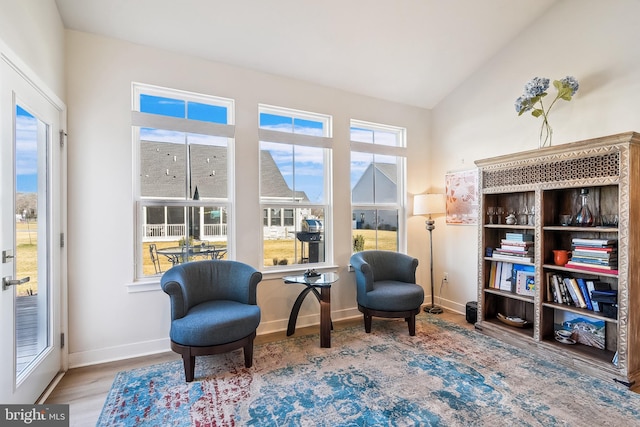 sitting room featuring wood finished floors, baseboards, and vaulted ceiling