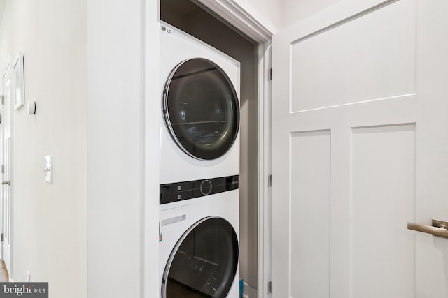 clothes washing area with laundry area and stacked washer and dryer