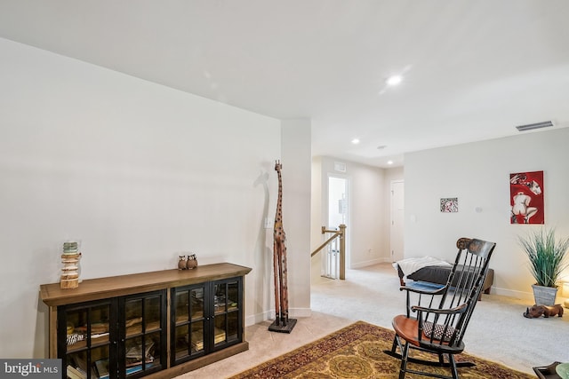 living area with visible vents, baseboards, light colored carpet, an upstairs landing, and recessed lighting