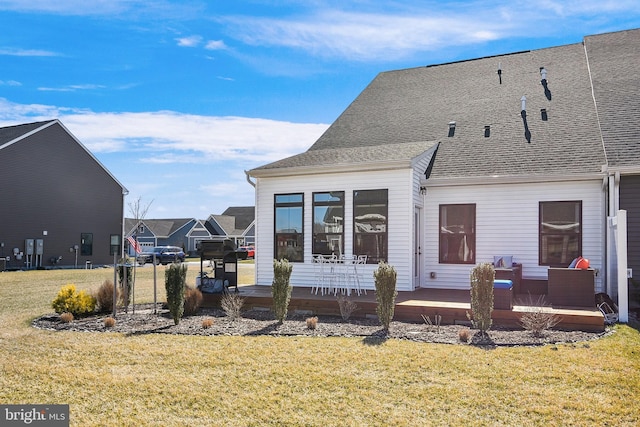 rear view of house with a yard and a wooden deck