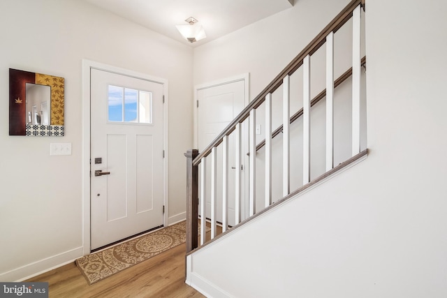 foyer featuring baseboards and light wood-type flooring