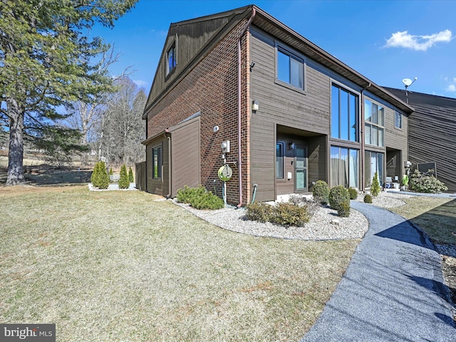 exterior space featuring brick siding and a lawn