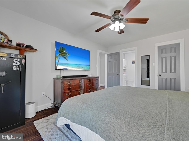 bedroom with baseboards, ensuite bath, dark wood finished floors, and a ceiling fan