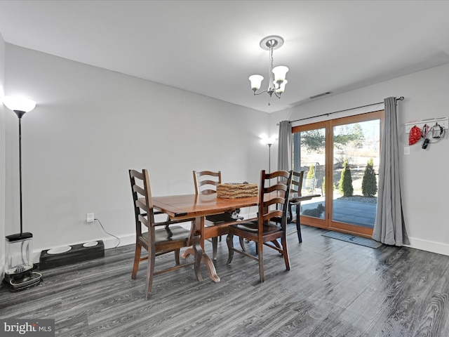 dining space with a notable chandelier, wood finished floors, visible vents, and baseboards