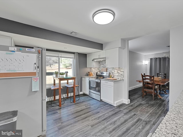 kitchen featuring under cabinet range hood, tasteful backsplash, stainless steel electric stove, white cabinetry, and freestanding refrigerator