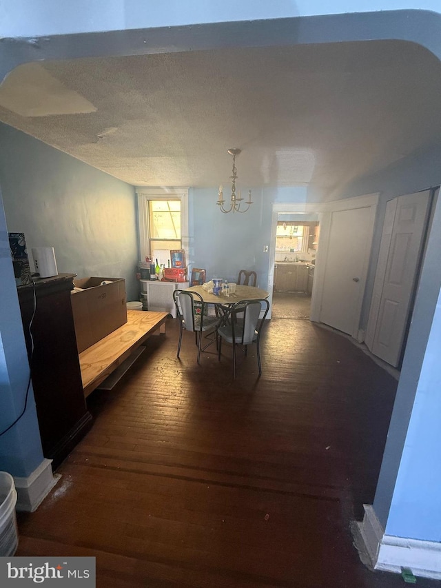 dining space with a textured ceiling and wood finished floors