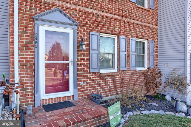 doorway to property featuring brick siding