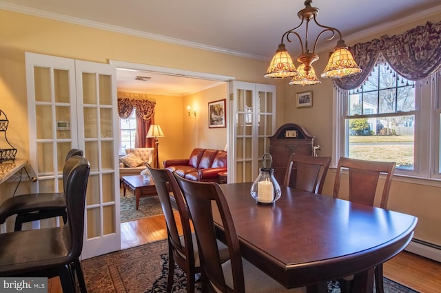 dining space with visible vents, ornamental molding, french doors, wood finished floors, and a baseboard radiator