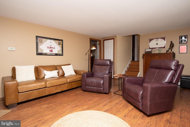 living area with stairway and wood finished floors