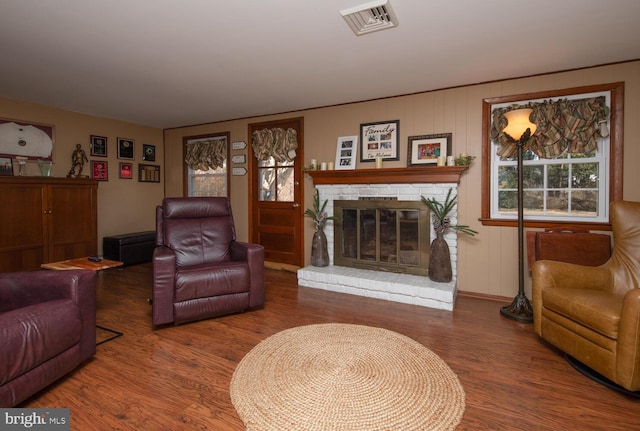 living area with visible vents, wood finished floors, and a fireplace