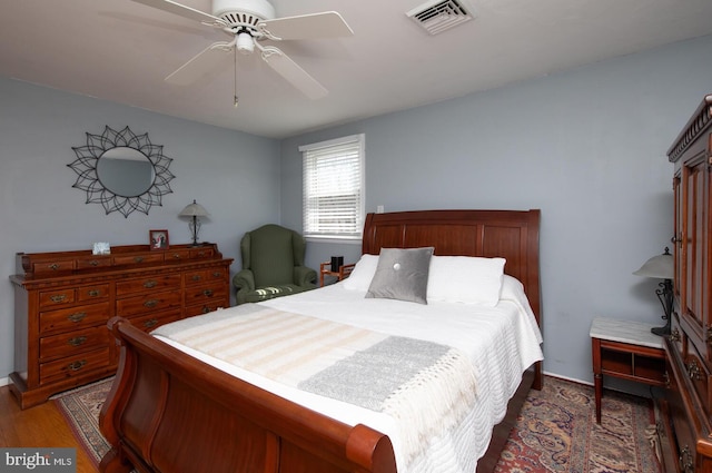 bedroom featuring a ceiling fan, wood finished floors, and visible vents