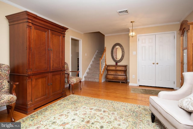 interior space featuring visible vents, crown molding, baseboards, stairs, and wood finished floors