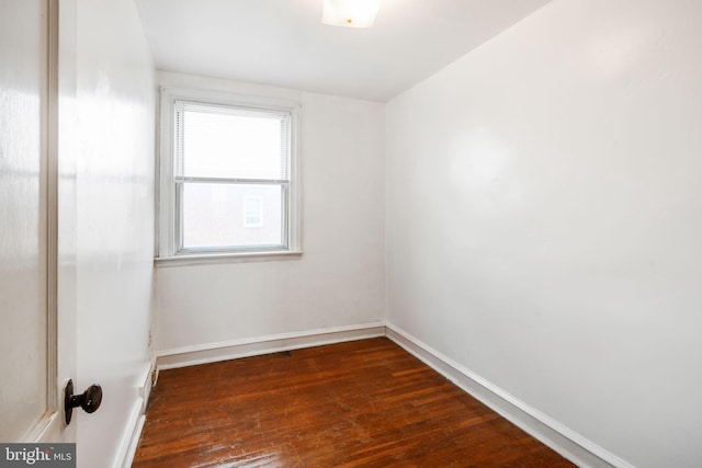 spare room featuring hardwood / wood-style floors and baseboards