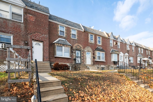 townhome / multi-family property featuring a high end roof, brick siding, and a residential view