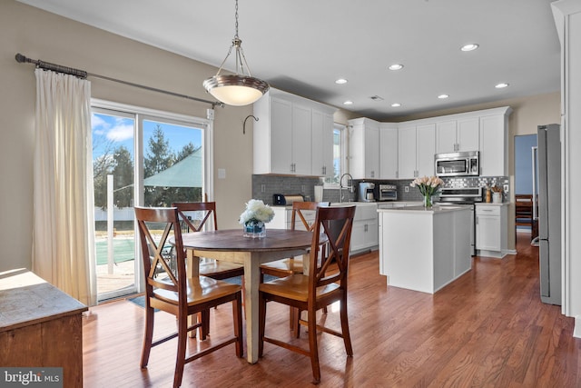 dining room featuring a toaster, recessed lighting, and wood finished floors