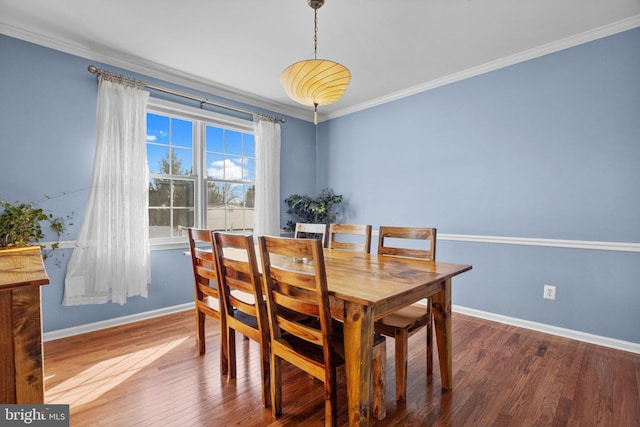 dining room with crown molding, baseboards, and wood finished floors