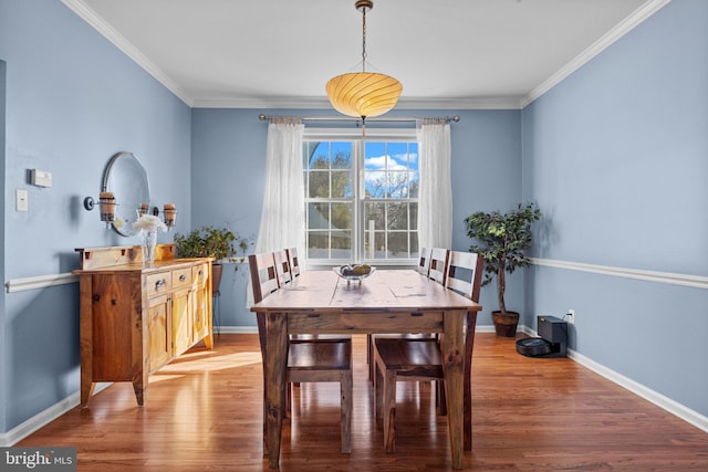 dining area featuring ornamental molding, baseboards, and wood finished floors