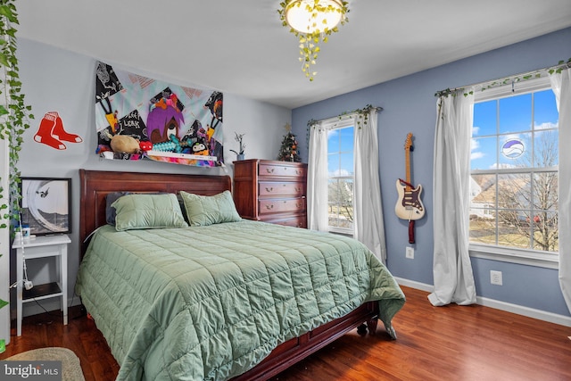 bedroom with baseboards and wood finished floors