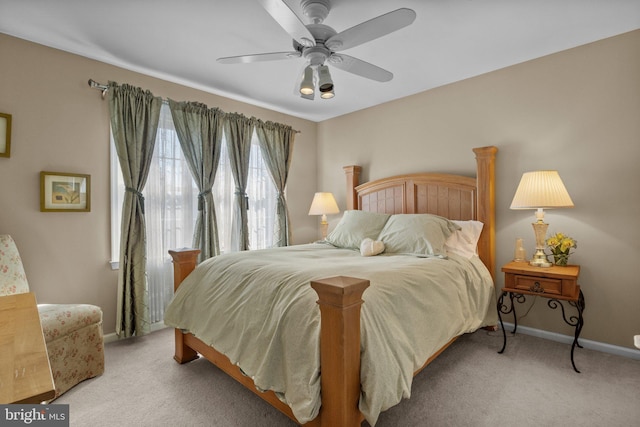 bedroom featuring light carpet, ceiling fan, and baseboards