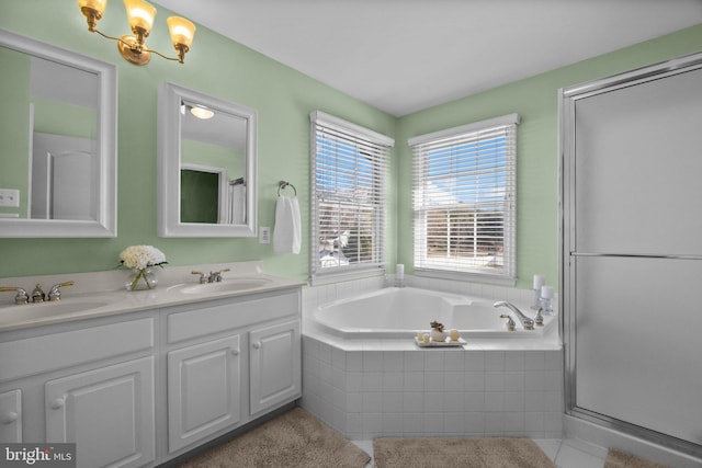 bathroom featuring a bath, a shower with shower door, double vanity, and a sink